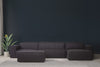 foto ambientada do sofá puff para quarto módulo maraú na cor grafite visto de frente com sofa no fundo em sala de estar
