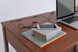 foto da escrivaninha para quarto com gavetas bali na cor caramelo focando no tampo com objetos em fundo branco
