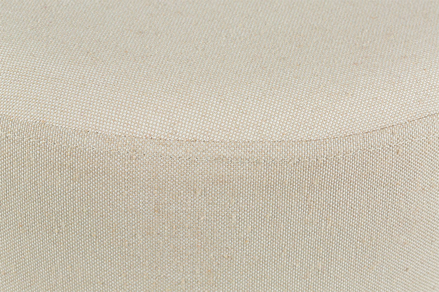 foto do banco puff mesa macaron na cor amêndoa e tecido bege focando no tecido