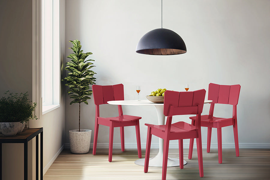 foto ambientada da cadeira para mesa de jantar uma na cor magenta ao redor de uma mesa branca em sala de jantar