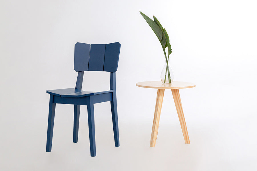 ambiente com cadeira de madeira uma azul ao lado de uma mesa natural
