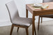 ambiente da cadeira fidalga base amendoa e tecido cinza visto na diagonal com mesa de jantar