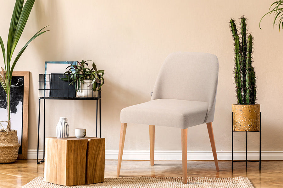 cadeira rosini base trigo e tecido bege em ambiente com plantas decorativos