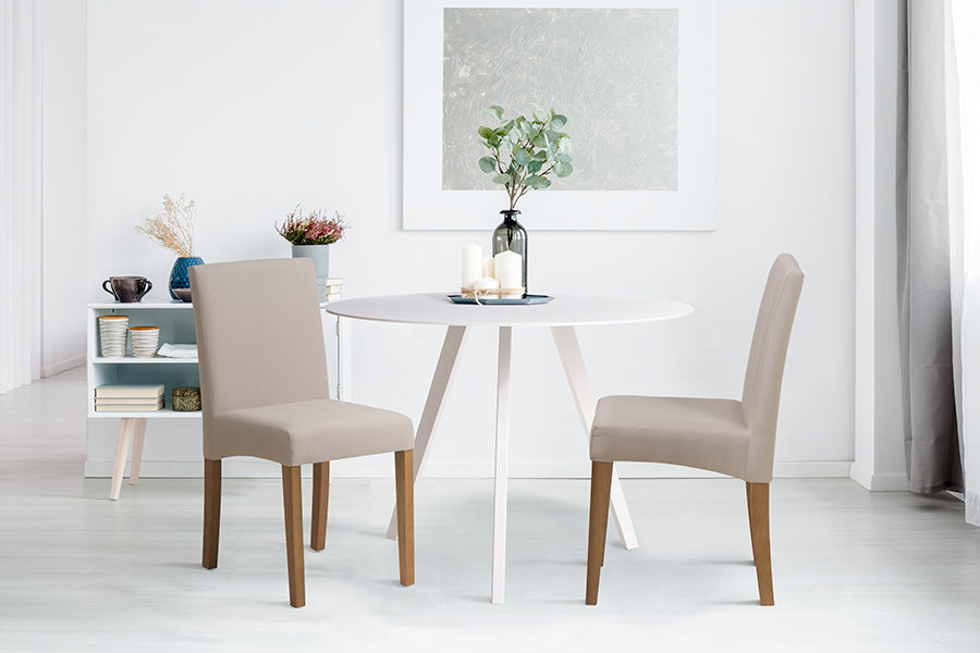 cadeira de madeira iolanda cru ambientadas ao lado de uma mesa redonda branca