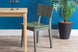foto ambientada cadeira para sala de jantar uma verde escuro visto na diagonal junto com mesa e planta