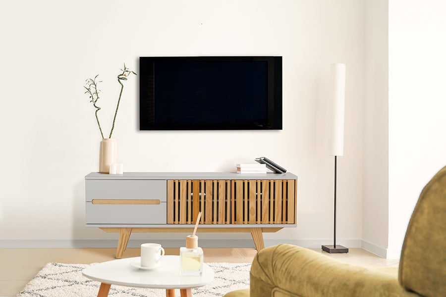 foto ambientada de sala de estar com rack laqueado para tv 1,65 m panteon off white visto de frente com objetos sobre rack e tv fixada na parede