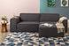 foto ambientada do sofá puff cinza módulo maraú na cor grafite visto de frente com sofa no fundo em sala de estar